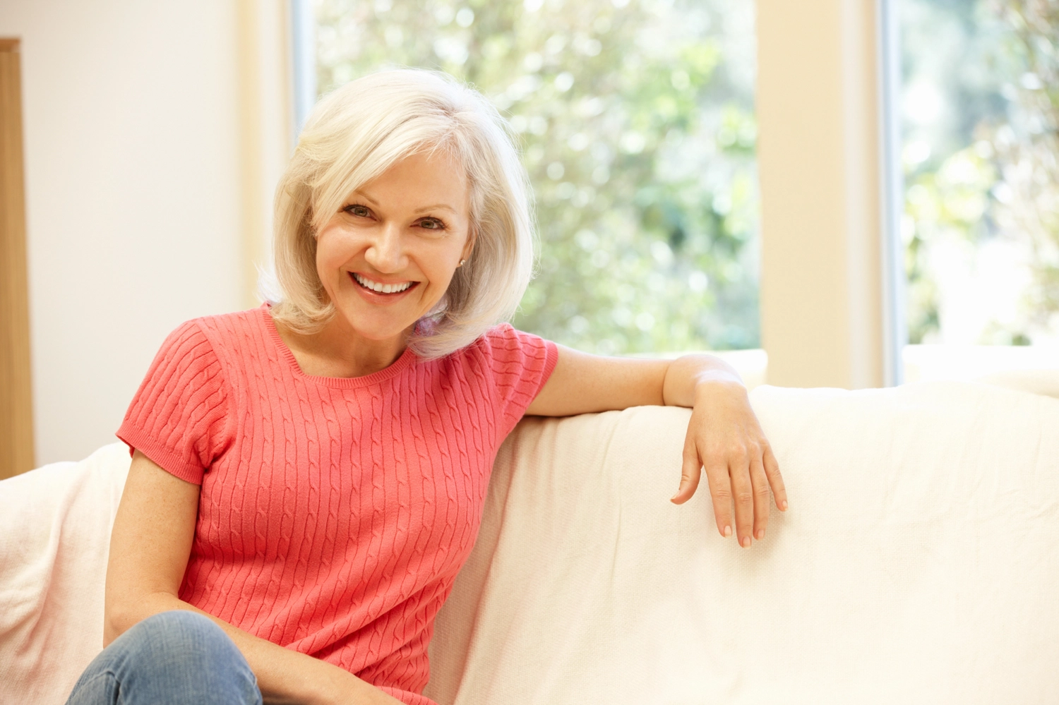 close up of smiling older woman sitting on a couch