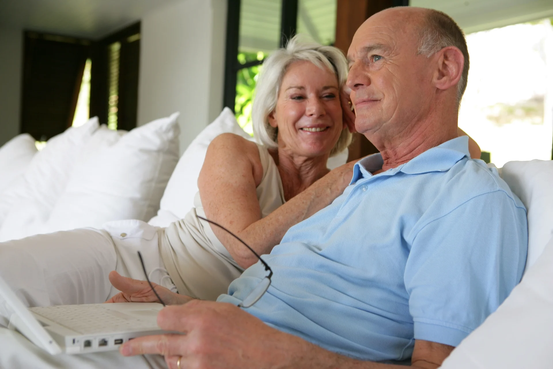 pleasant-looking elderly couple sitting up in bed