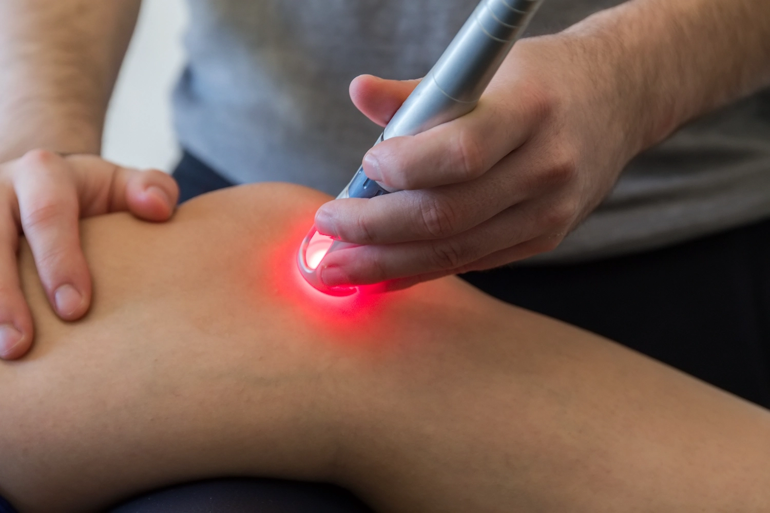 close up of laser therapy being performed on patient's knee