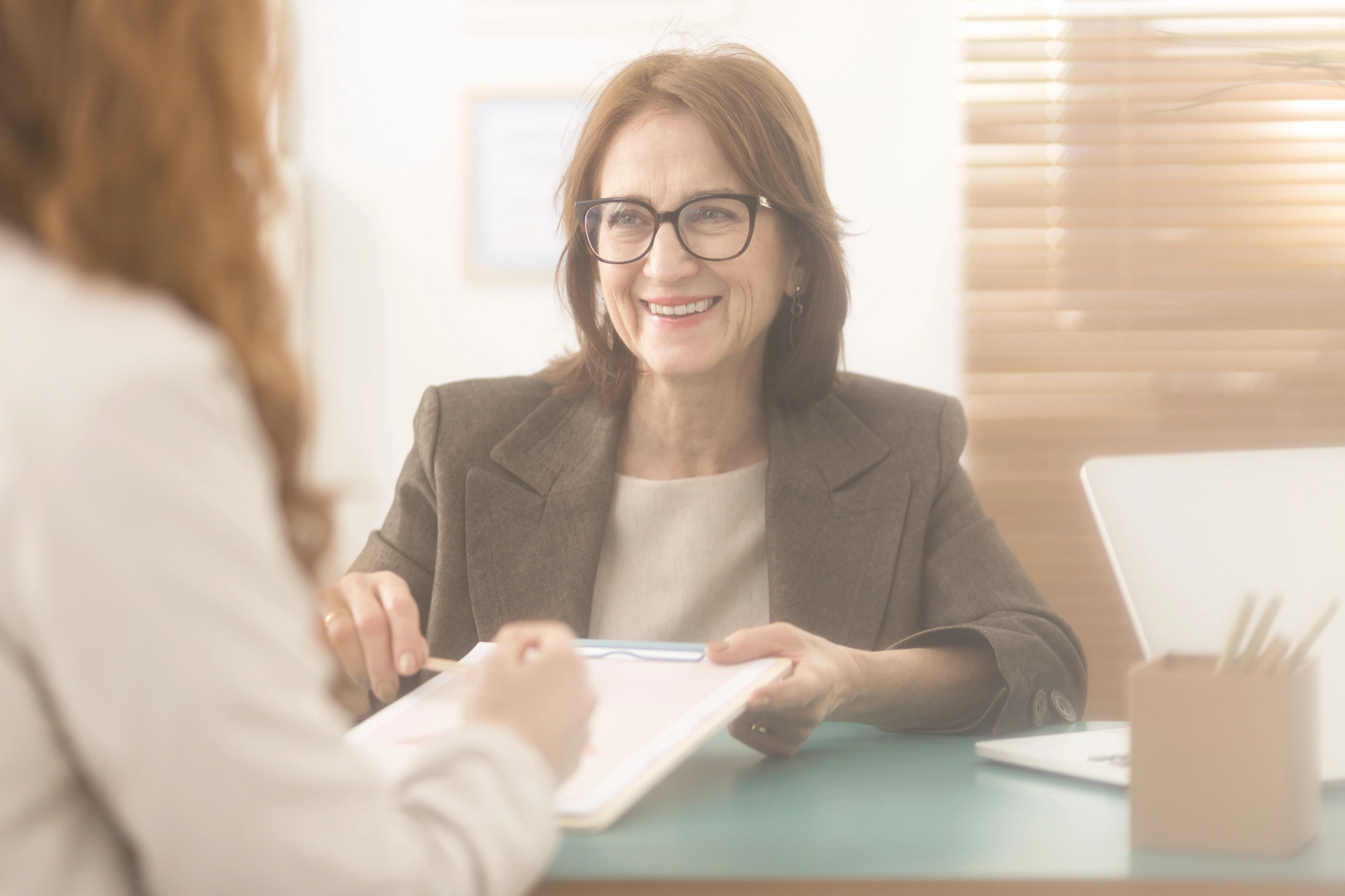 close up of woman talking to person with a clipboard