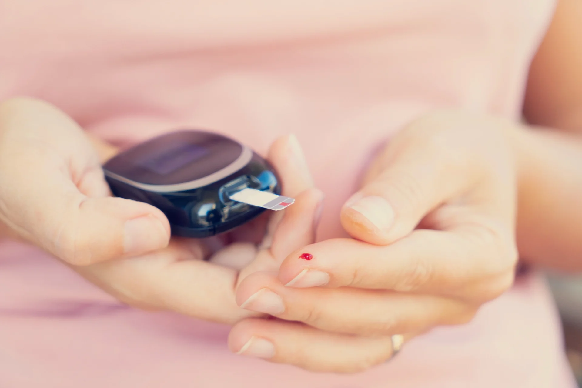 close up of a woman pricking her finger to take blood sugar measurement
