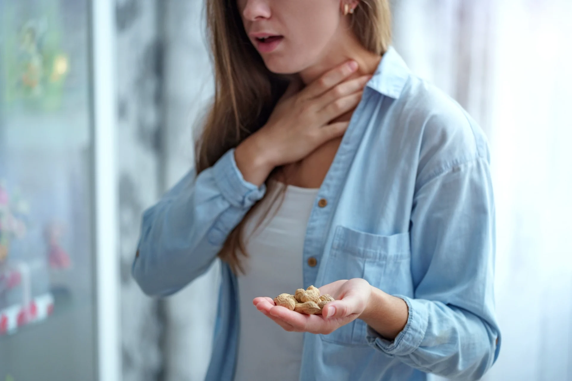 woman holding peanuts in hand and having allergic reaction