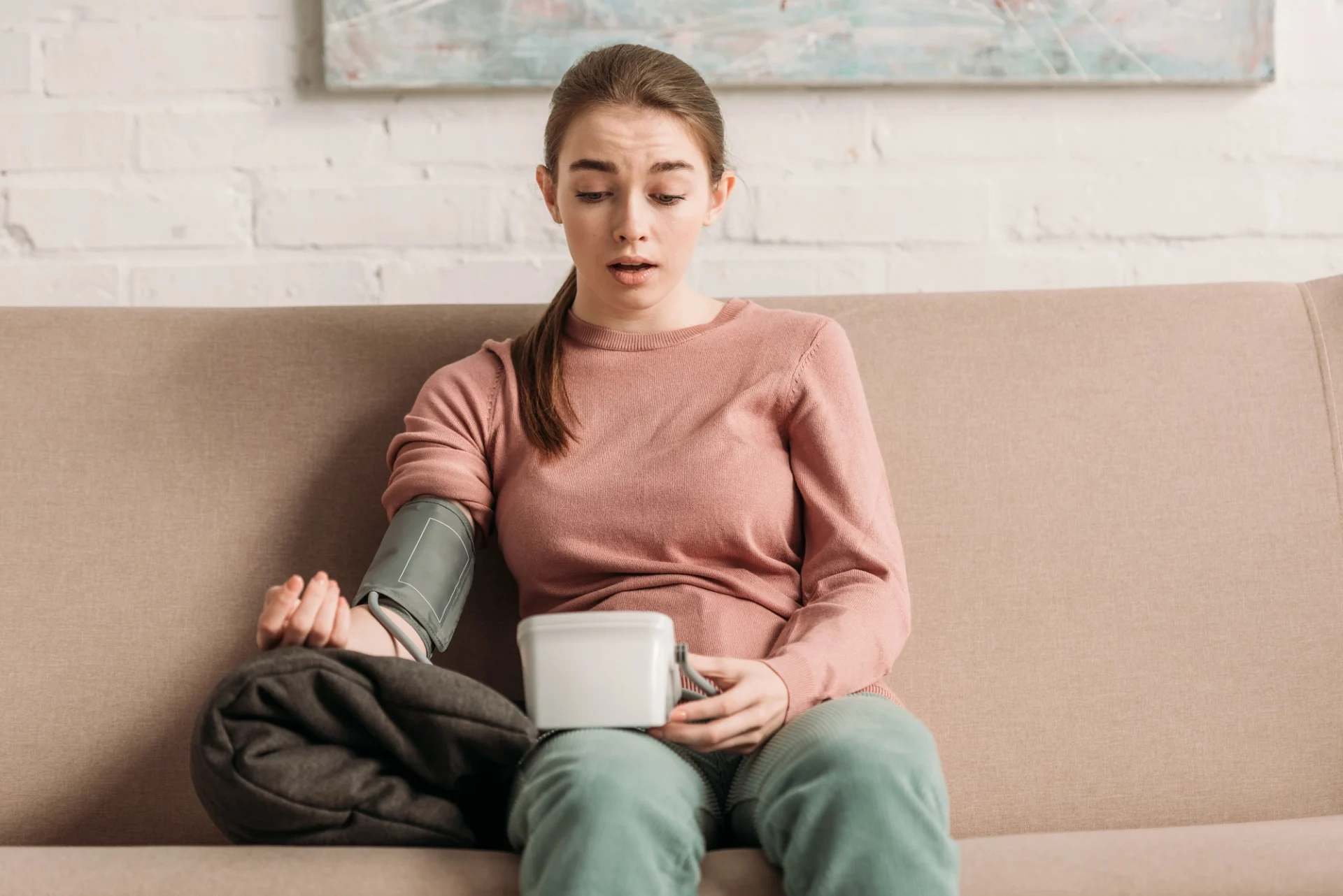 woman with surprised look on her face measuring her blood pressure
