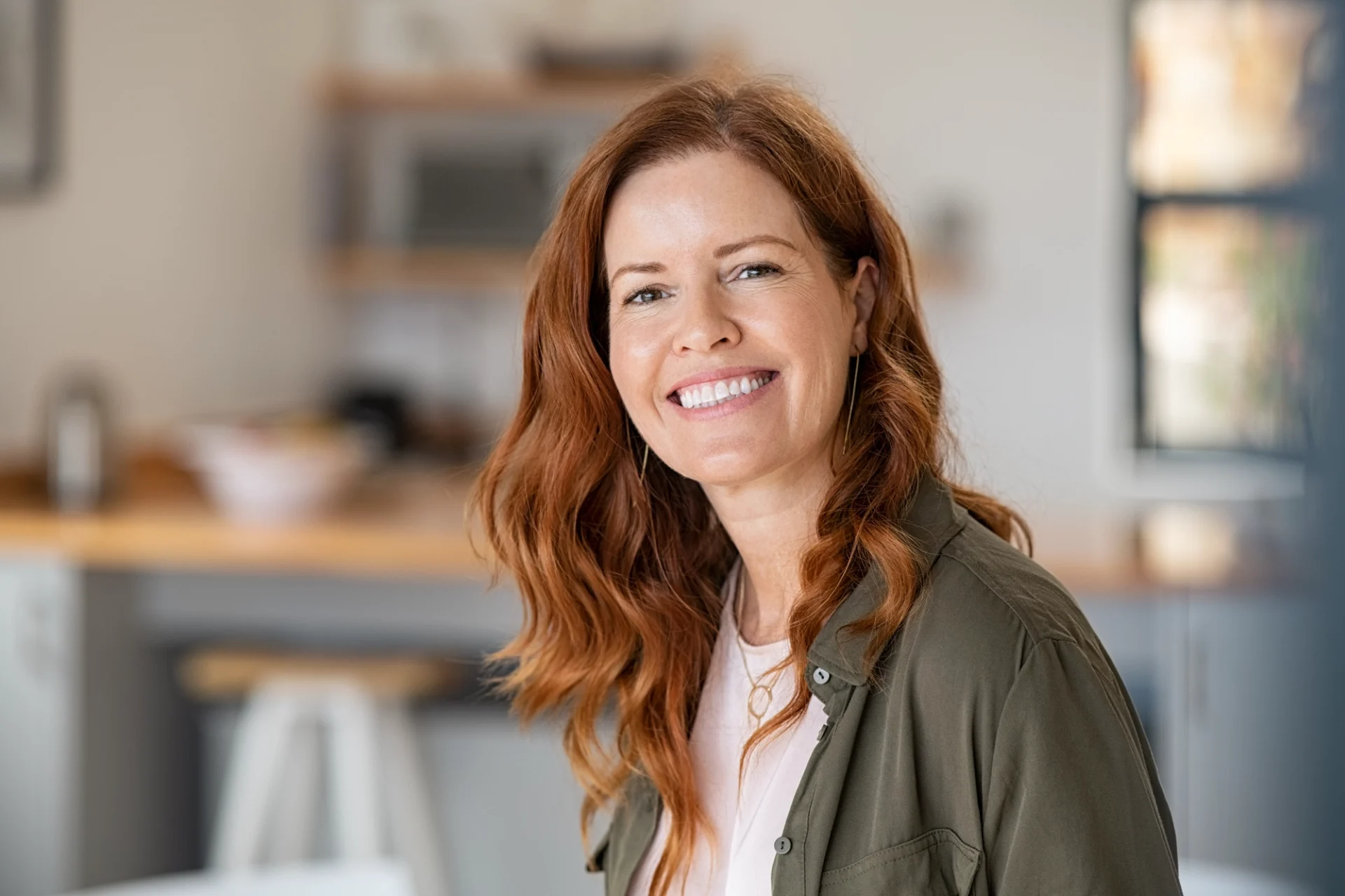 close up of a red-haired happy middle-aged woman smiling at the camera